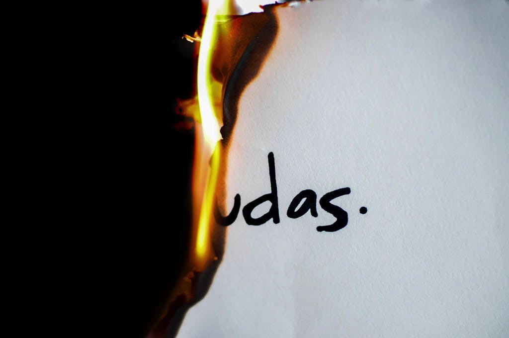 A piece of paper with handwritten text 'udas' partially engulfed in flames.